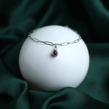 Silver paperclip chain bracelet with hidden photo inside, a meaningful personalized keepsake.