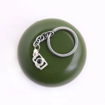 Camera-shaped projection photo keychain, perfect for preserving memories in a unique way.